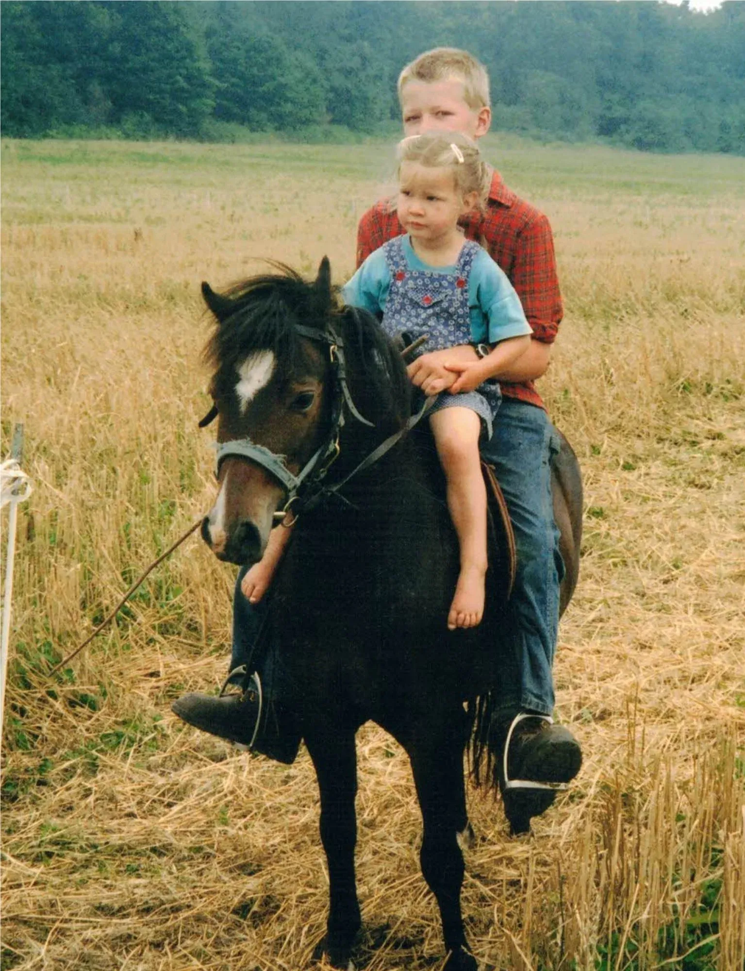 Young Ingrid riding a pony with one of her older brothers